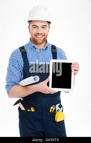 Smiling handsome young builder holding blank screen tablet Stock Photo