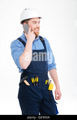 Cheerful bearded young builder talking on mobile phone Stock Photo