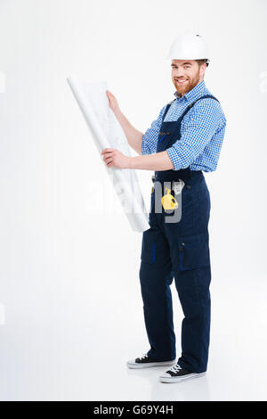 Smiling handsome young man builder standing and working with blueprint Stock Photo