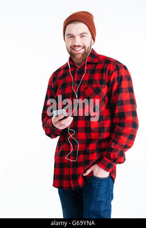 Smiling bearded man listening to music with earphones isolated on the white background Stock Photo