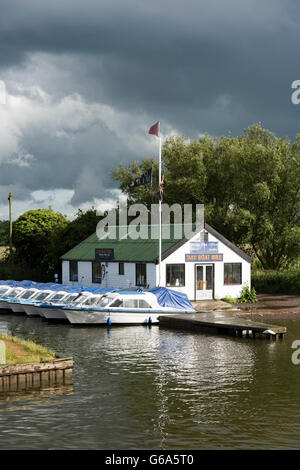 A boat yard at Wroxham in the Norfolk Broads UK withrain clouds ...