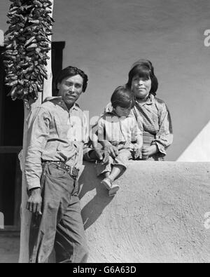 1930s PORTRAIT NATIVE AMERICAN INDIAN FAMILY MOTHER FATHER DAUGHTER LOOKING AT CAMERA SAN ILDEFONSO PUEBLO NEW MEXICO USA Stock Photo