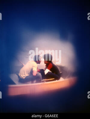 1970s AFRICAN AMERICAN COUPLE IN BOAT KISSING ROMANTIC LOVE Stock Photo
