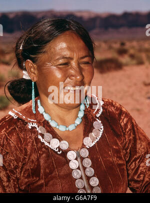 1950s NATIVE AMERICAN NAVAJO INDIAN WOMAN WEARING HAND MADE JEWELRY AND DRESS ADORNED WITH AMERICAN COINS SILVER QUARTERS Stock Photo