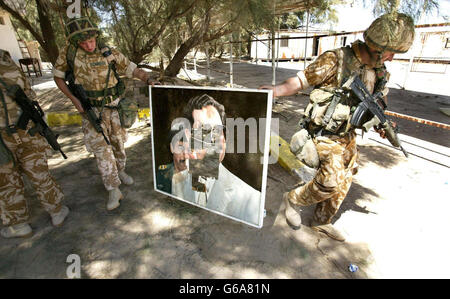 Picture released Thursday 3 April, 2003, of British Soldiers part 2CS regiment RLC, after finding a defaced portrait in the grounds of the mansion of Saddam Hussain's cousin, Ali Hassan Al Majid, also known as 'Chemical Ali', * ... after local people looted the house near Basra. PA Photo: Dan Chung/The Guardian/MOD Pool. Stock Photo