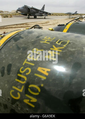 British Royal Air Force Harrier GR7 taxis past a bomb-trolley of cluster bombs prior to them being loaded at its base in Kuwait. The United States admits it has used them in Iraq; Britain says it has them, but would not use them in built-up areas. *... Iraq says they have killed dozens of civilians; and human rights groups insist they should be banned. Cluster bombs are deadly but unpredictable - each contain over 200 bomblets the size of a drinks can which scatter over an area the size of two soccer pitches, most exploding on impact and capable of tearing through quarter of an inch of steel. Stock Photo