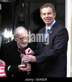 Britain's Prime Minister Tony Blair helps with a donation to launch the Greater London Fund for the Blind's Geranium Day Appeal outsde 10 Downing Street with Sir John Mills, Vice President of the GLFD. Stock Photo