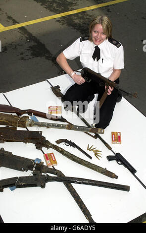 Sian Price from West Midlands Police at Telford in Shropshire, with the latest batch of weapons handed in there during the nationwide firearms amnesty. These include a German MP40 and (in foreground) some of the sixteen .50 calibre Browning machine guns handed in anonymously by a driver. * The amnesty runs until the end of the month. Stock Photo