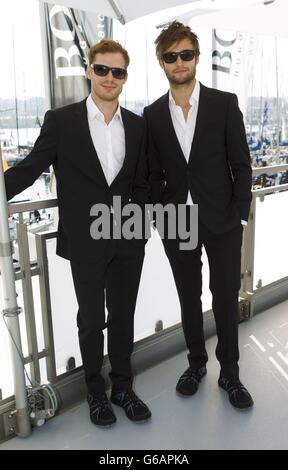 Actors Douglas Booth (right) and Sam Reid before the Artemis Challenge at Aberdeen Asset Management Cowes Week where they sailed onboard the Open 60 racing yacht, Hugo Boss, with round the world yachtsman Alex Thomson. Stock Photo