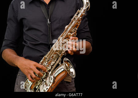 Nice hands touching a silver saxophone, black background Stock Photo