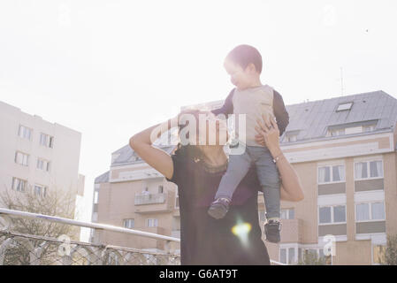 Mother carrying little boy on shoulder Stock Photo
