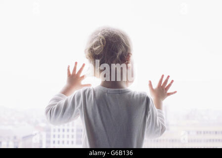 Baby looking out of window Stock Photo