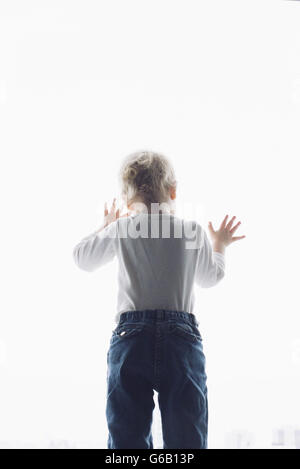 Baby looking out of window Stock Photo