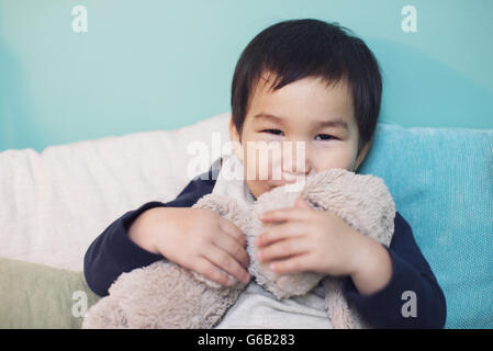 Little boy hugging stuffed toy rabbit Stock Photo