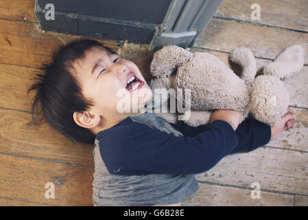Little boy playing with stuffed toy Stock Photo