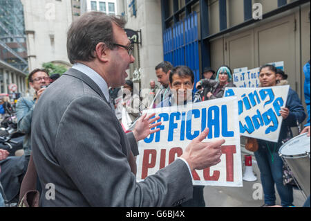 London, UK. June 29th, 2016. A man in a suit walking by talks to United Voices of the World cleaners employed by anti-union cleaning contractor Thames Cleaning at 100 Wood St during the rally on the 22nd day of their strike. Credit:  Peter Marshall/17�Թ����� Live News Stock Photo