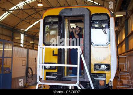 Electrical Mechanical tester Simon Croxall works on a train at the Railcare depot in Wolverton near Milton Keynes which has been bought out by Knorr-Bremse Rail Systems. Stock Photo
