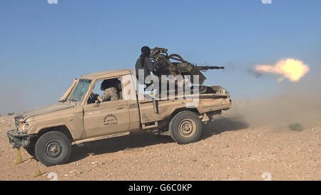 Islamic State fighters use pickup truck mounted heavy machine guns during combat against Syrian government forces June 20, 2016 near Palmyra, Syria. The still image is captured from a propaganda video released by the Islamic State of Iraq and the Levant. Stock Photo