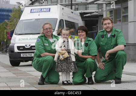 Three-year-old Casey McLean with paramedics left to right Andy Houston, June Maxwell and Julie Grainger, who saved her life after she went into cardio /respiratory arrest in Glasgow. Stock Photo