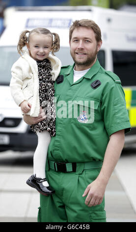 Three-year-old Casey McLean with paramedics Andy Houston one of the paramedics who saved her life after she went into cardio /respiratory arrest in Glasgow. Stock Photo