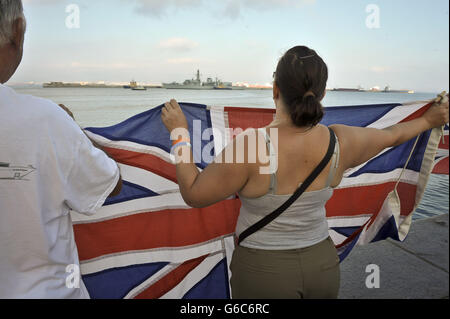 Gibraltarians wave Union Flags as the Royal Navy warship HMS Westminster arrives into the harbour at Gibraltar for a scheduled visit ahead of exercises in the Mediterranean. Stock Photo