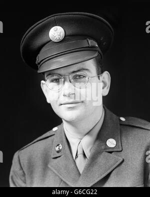 1940s PORTRAIT OF MAN WORLD WAR II ENLISTED SOLDIER WEARING ARMY UNIFORM LOOKING AT CAMERA Stock Photo