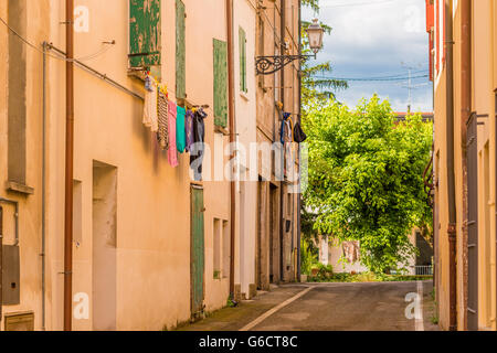 clothes hung out to dry from the windows of a street of a village in Romagna, Italy Stock Photo