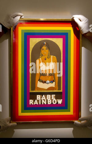 Sotheby's employees adjust a piece of work entitled 'Babe Rainbow' by Peter Blake, part of The New Situation - Art in London in the Sixties exhibition at Sotheby's auction house in London. The exhibition runs at the auction house from 4 - 11 September when a selection of works will then go on sale. Stock Photo