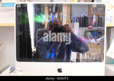 Photographer self portrait in computer screen in his office. Stock Photo