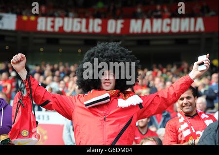 A Manchester United fan wears a Marouane Fellaini wig in the stands Stock Photo