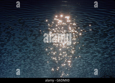 Aerial view of sun reflecting off ripples of water in a lake Stock Photo