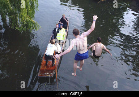 Cambridge students Sam Prentice, 21, (blue shorts), from Cambridge, Massachusetts, USA and Tom Simpson, 19, from Whitley Bay, near Newcastle upon Tyne, who are both studying at Clare College, jump from a bridge over the river Cam in Cambridge, after celebrating the end of term by going to Clare May Ball. * The college balls held during May Week - a fortnight in June - are the traditional way for students to let their hair down after taking their end-of-year exams. Stock Photo