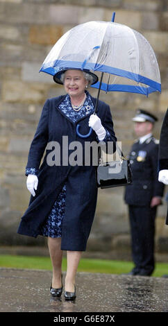 Queen Elizabeth II carrying an umbrella to protect her from the torrential rain, before inspecting members of the 1st Battalion The Royal Scots (Royal Regiment), at the traditional Ceremony of the Keys outside the Palace of Holyroodhouse in Edinburgh. Stock Photo