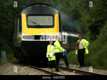 Police officers stand on the tracks, in front of the First Great Western express train, after a collision with a minibus. Three minibus passengers died and three others were seriously injured when their vehicle was hit by the high-speed train on an unmanned rail crossing. There were at least 11 people in the minibus, which was on farmland at Pools Crossing, two miles west of Evesham in Worcestershire, when the collision with the train occurred at 8.24am. Stock Photo