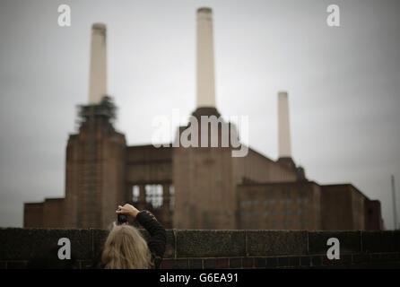A woman taking a photograph over a wall of Battersea Power Station during the Open House London architectural showcase, in London. Stock Photo