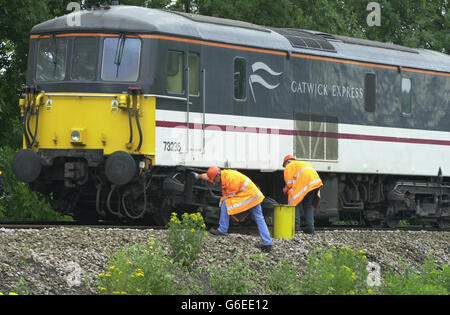 Engineers examine the derailed bogie of the rear locomotive of the Gatwick Express train which came off the track, near Redhill station in Surrey. * The accident happened at 0520 when the train was travelling at about 80 mph and closed two lines and caused severe disruption to trains on the London to Brighton route and other south coast routes. One woman passenger exacerbated a previous whiplash injury but none of the other 21 people on board was hurt. Stock Photo