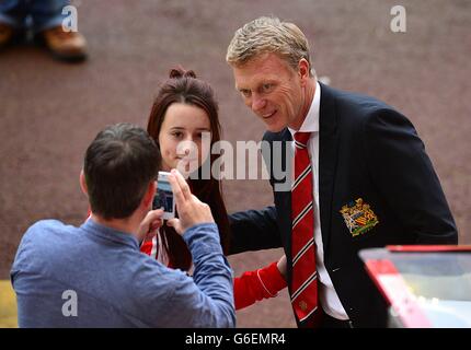 A Manchester United fan poses for a photograph with a half-and-half ...