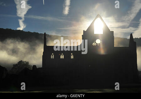 The Autumn sun rises behind Tintern Abbey in the Wye Valley. Stock Photo