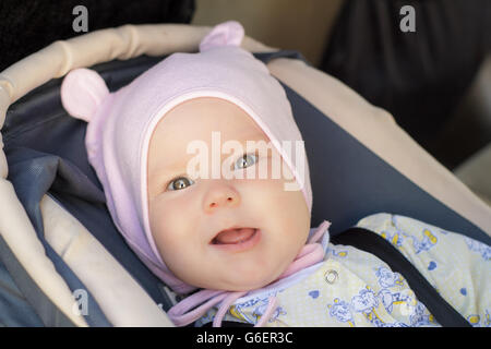 little newborn baby girl rests in the car seat Stock Photo