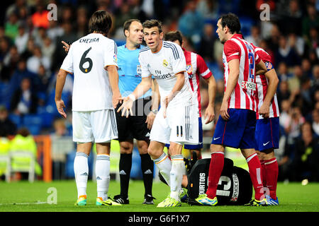 Real Madrid's Gareth Bale (centre) argues his point after fouling the Atletico Madrid goalkeeper Thibaut Courtois (floor) Stock Photo