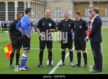 The Duke of Cambridge watches as referee Howard Webb toss the coin before the Southern Amateur League football match between Polytechnic FC and Civil Service FC in Buckingham Palace's garden, central London. Stock Photo