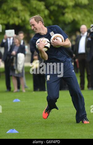 The Duke of Cambridge trains with members of the Royal household, during the second half of a match between the Polytechnic FC and the Civil Service FC, in the grounds of Buckingham Palace's garden, central London. Stock Photo