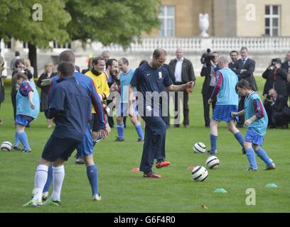 The Duke of Cambridge trains with members of the Royal household, during the second half of a match between the Polytechnic FC and the Civil Service FC, in the grounds of Buckingham Palace's garden, central London. Stock Photo