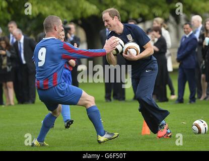 The Duke of Cambridge trains with members of the Royal household, during the second half of a match between the Polytechnic FC and the Civil Service FC, in the grounds of Buckingham Palace's garden, central London. Stock Photo