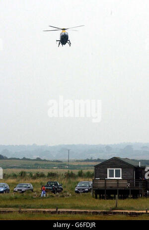 Suffolk Police helicopter in Lowestoft, with locals as the search for missing 15 year old Rory Unwin-Rose continues. The teenager was last seen at the party on Walberswick beach, near Lowestoft, at around 4am Thursday morning, when he walked away from a group of friends, leaving behind clothing and his mobile phone. The Suffolk police helicopter has joined the coastguard, lifeboats and Suffolk Search and Lowland Rescue teams in trying to find the boy. Stock Photo