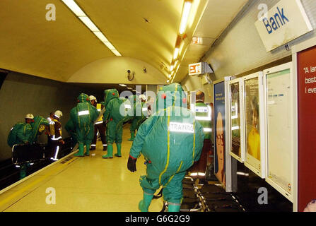 Medical personnel dressed in thick green rubber suits attend a simulated terrorist attack at Bank underground station in the centre of London. University College Hospital treated 'victims' of the exercise, who went through a rigorous decontamination process surrounded by police and hospital staff in full protective gear. Stock Photo