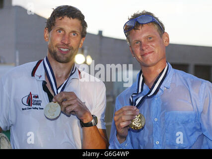 British yachtsmen Simon Hiscocks (left) and Chris Draper hold the gold medals they won in the 49er class at the sailing World Championships in Cadiz, Spain, after being ceremonially thrown into the swimming pool by the British team's bronze and silver winners. Britain's sailors finished as the top-performing team at the competition after taking home a collective haul of two golds, a silver and two bronze medal. Stock Photo
