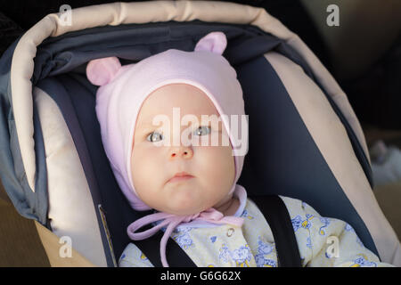 little newborn baby girl rests in the car seat Stock Photo