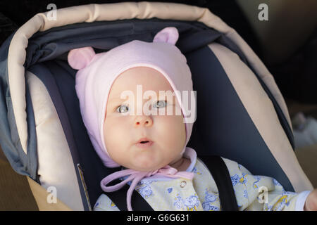 little newborn baby girl rests in the car seat Stock Photo