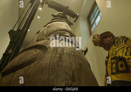 Master carver and a member of the Nisga'a Eagle-Beaver clan Chief Gadeelip Alver Tait stands beside an early and important totem pole from the Nisga'a Nation in British Columbia, at a ceremony inside the British Museum in central London. The pole, dating from around 1850, was acquired by the museum in 1933 but has never before been seen by the public. The eight metre red cedar pole will be one of the star objects in the museum's forthcoming 'Living and Dying' exhibition opening on November 3. Stock Photo